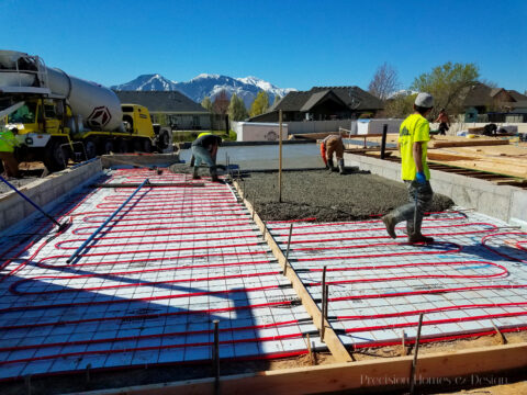 Hydronic Heating Systems: Seven things you'll want to know 1 Construction site pouring concrete foundation with radiant hydronic heating system and workers in safety gear.